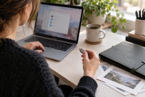 Woman holding a USB-C flash drive beside a Mac laptop